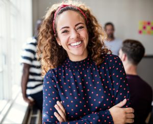 Smiling Woman with Curly Hair Crossing Arms and Smiling